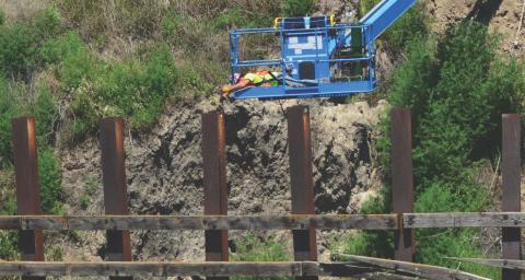 A worker prepairs old cribbing for removal from the bank of Salt Creek, downstream of 27th Street