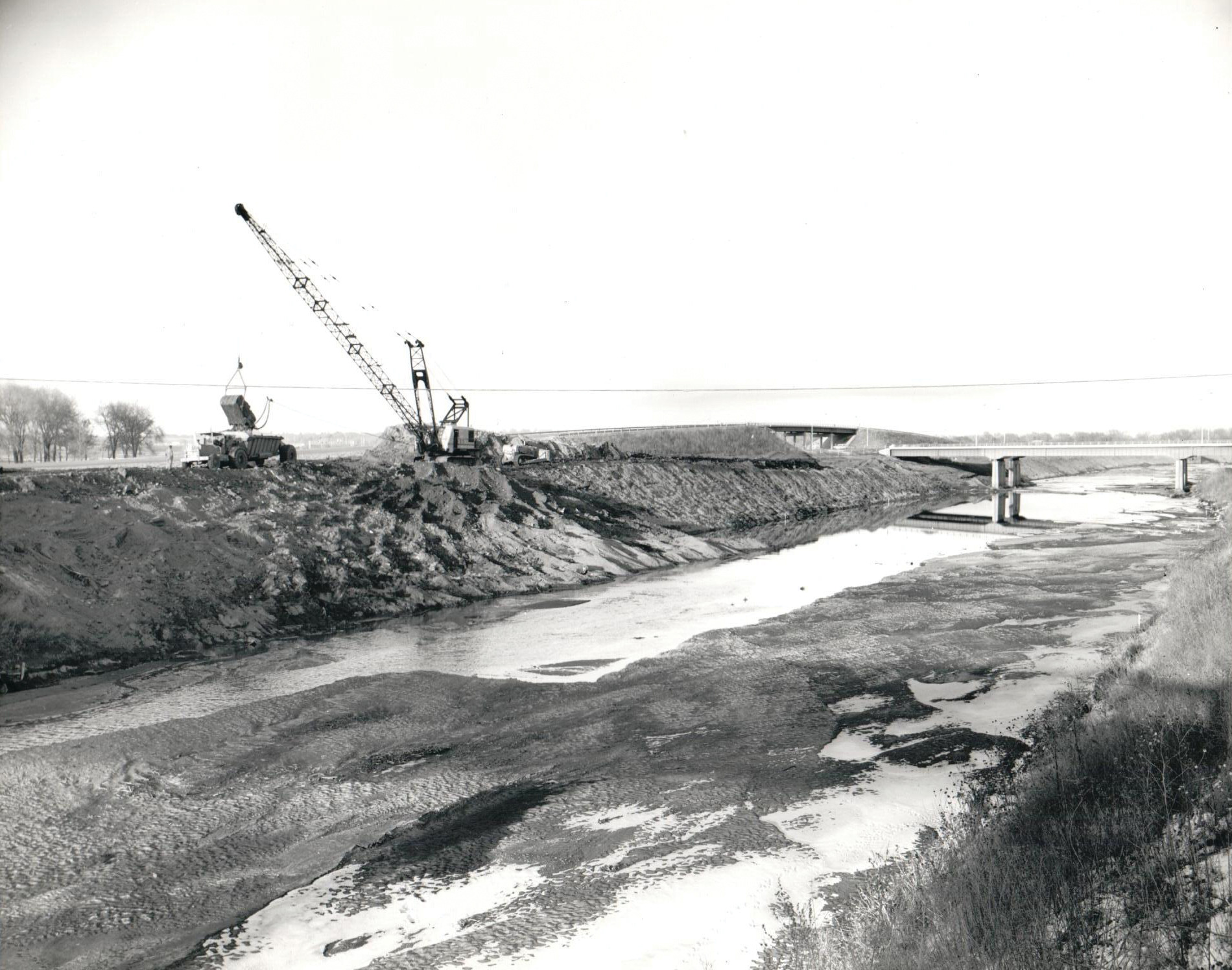 Salt Creek Levee construction in December 1964, along SYA highway (now called Sun Valley Boulevard), near Oak Lake. The Interstate 180 bridge is at right.